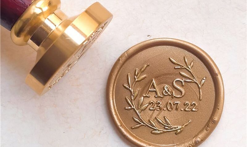 Sello de lacre personalizado con iniciales y ramas de olivo